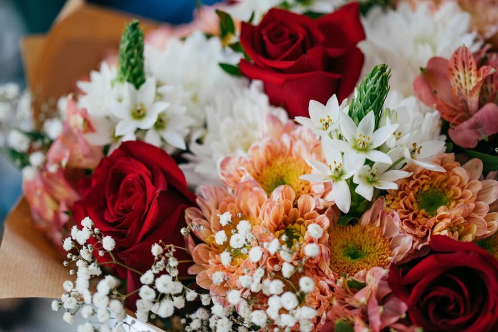 A colorful bouquet featuring red roses, white star of Bethlehem, and chrysanthemums.